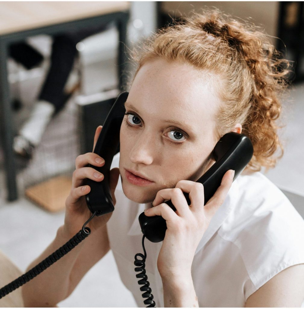 women using 2 landline phones